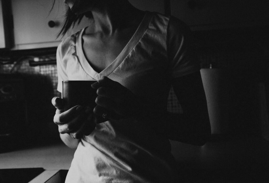 Woman pausing with a mug of coffee for a quiet moment to calm mom guilt