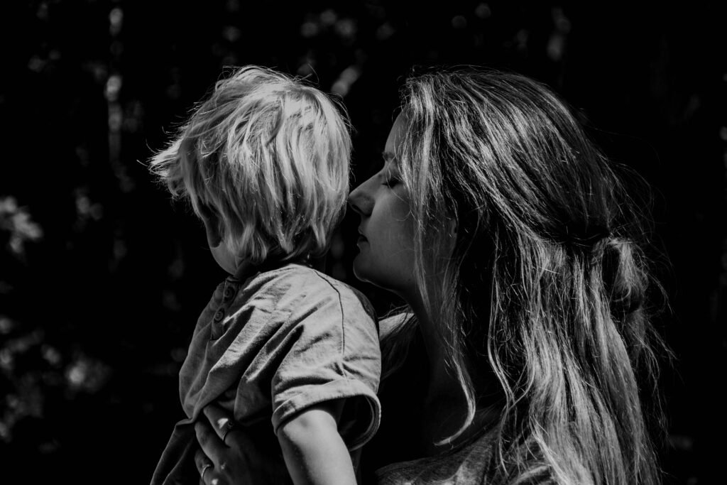 Mother kissing her son's cheek to reconnect and repair after a hard moment